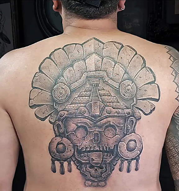Pieza mexica con penacho y orejeras en negro y gris que cubre la espalda