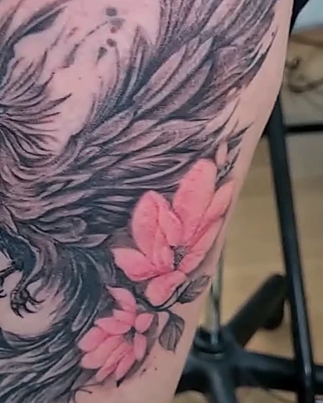 Fénix en gris con flores rosas, en el muslo