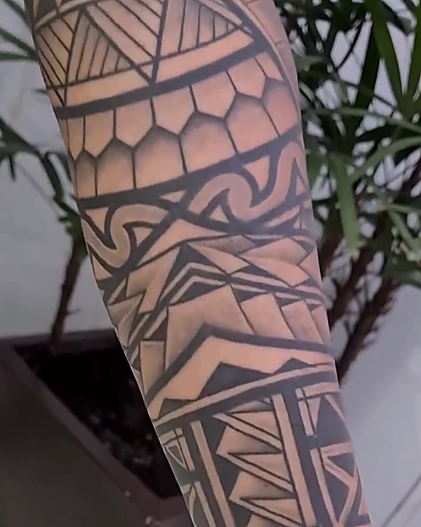 Manga geométrica de inspiración polinesia en negro, en el antebrazo