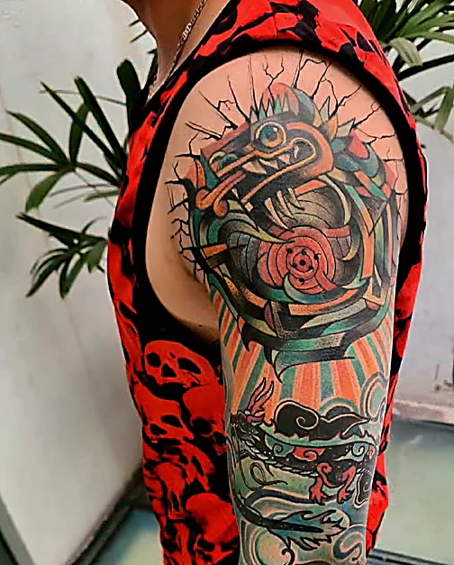 Manga a color con motivos mexicas en verde, naranja y rojo, en el hombro y el brazo